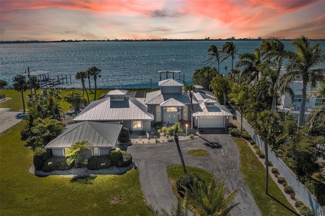 aerial view at dusk featuring a water view