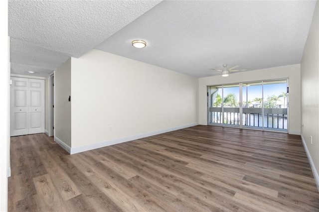 spare room with ceiling fan, hardwood / wood-style floors, and a textured ceiling