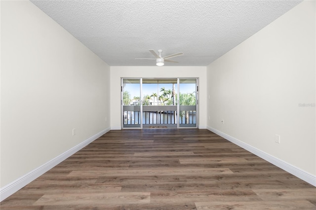 unfurnished room with ceiling fan, dark wood-type flooring, and a textured ceiling