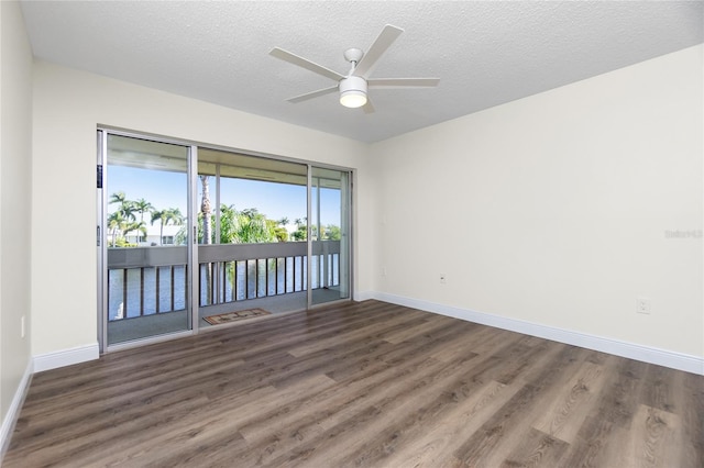 spare room featuring ceiling fan, dark hardwood / wood-style floors, and a textured ceiling