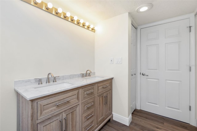 bathroom with vanity, wood-type flooring, and a textured ceiling