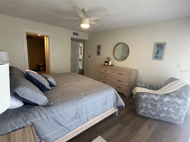 bedroom featuring a textured ceiling, dark wood-type flooring, and ceiling fan