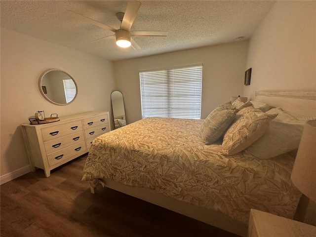 bedroom featuring a textured ceiling, dark wood-type flooring, and ceiling fan