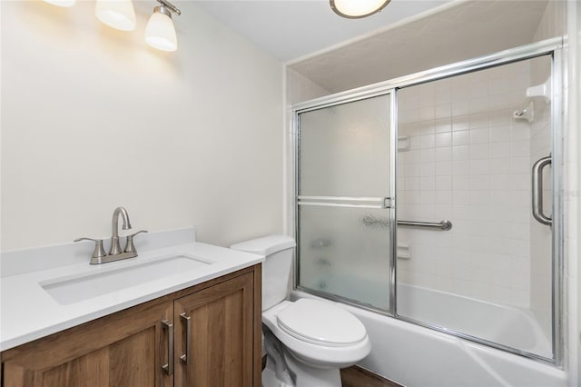 full bathroom with bath / shower combo with glass door, vanity, and toilet