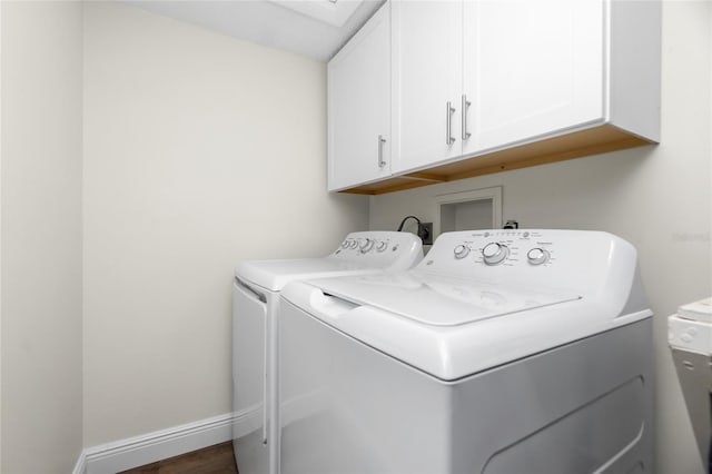 laundry room featuring dark wood-type flooring, cabinets, and washer and clothes dryer