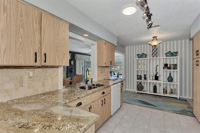 kitchen featuring light stone countertops, light tile flooring, track lighting, sink, and a textured ceiling