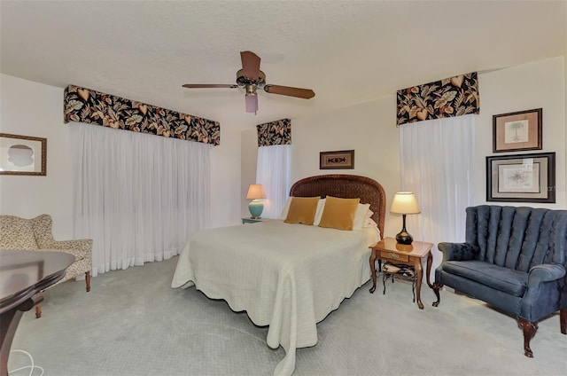 bedroom with light carpet, a textured ceiling, and ceiling fan