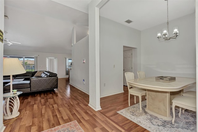 dining room featuring ceiling fan with notable chandelier and hardwood / wood-style flooring