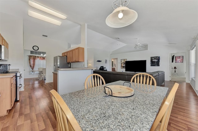 dining space with vaulted ceiling, ceiling fan, and hardwood / wood-style flooring