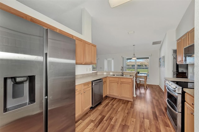 kitchen featuring light brown cabinetry, sink, hanging light fixtures, light hardwood / wood-style floors, and stainless steel appliances