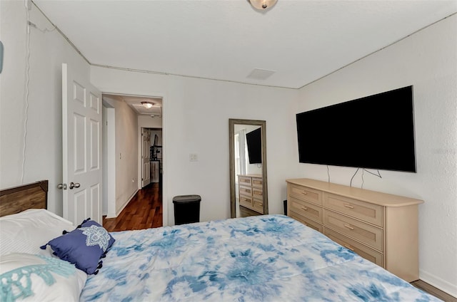 bedroom with dark hardwood / wood-style flooring