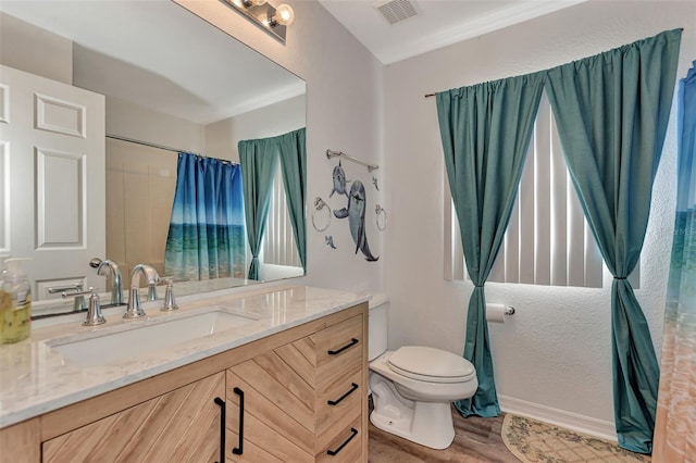 bathroom featuring oversized vanity, toilet, and hardwood / wood-style flooring