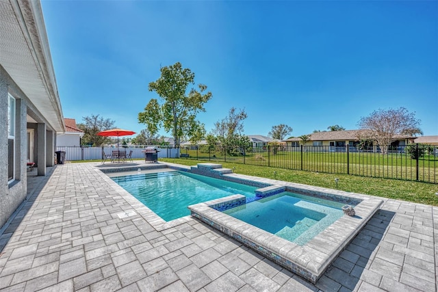 view of swimming pool featuring a lawn, a patio area, and an in ground hot tub