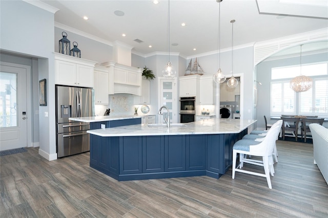 kitchen with stainless steel appliances, backsplash, pendant lighting, white cabinets, and washer / clothes dryer