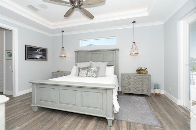 bedroom featuring ceiling fan, a tray ceiling, and dark hardwood / wood-style flooring