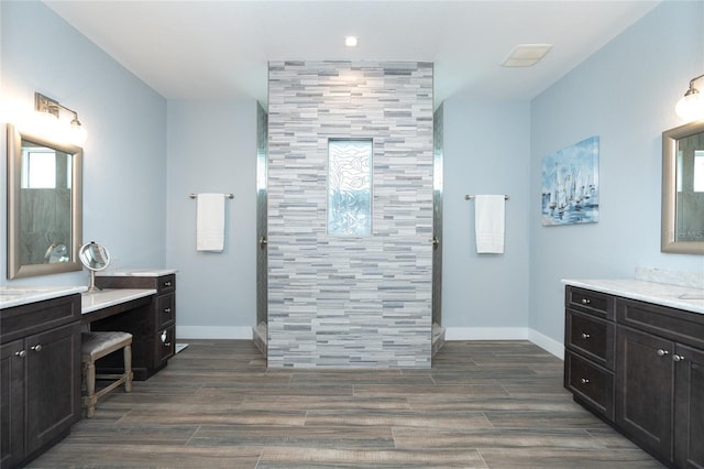 bathroom featuring walk in shower and vanity