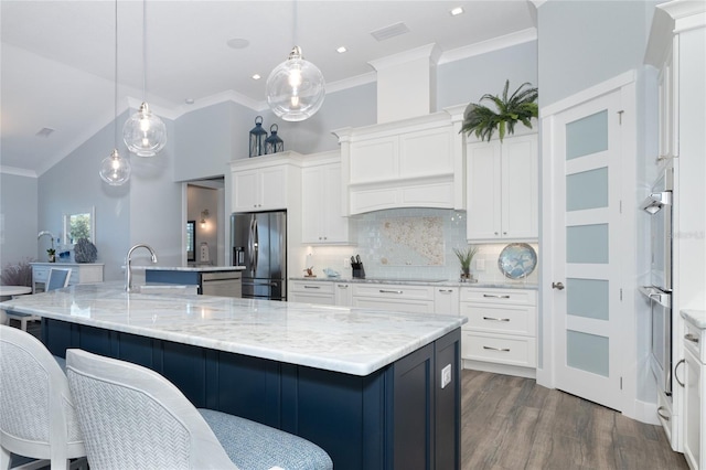 kitchen with pendant lighting, white cabinets, appliances with stainless steel finishes, decorative backsplash, and a large island