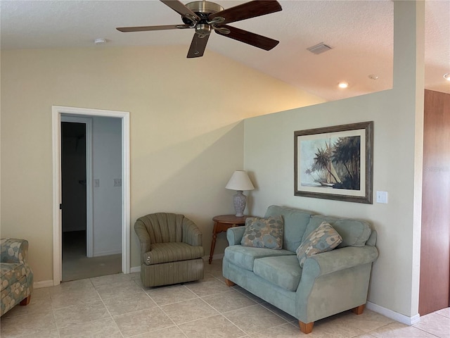 tiled living room featuring a textured ceiling, ceiling fan, and vaulted ceiling