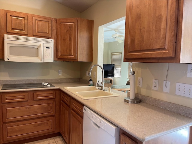 kitchen with light tile patterned floors, white appliances, sink, and ceiling fan