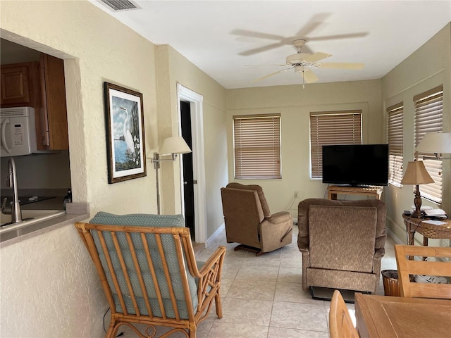 tiled living room featuring ceiling fan