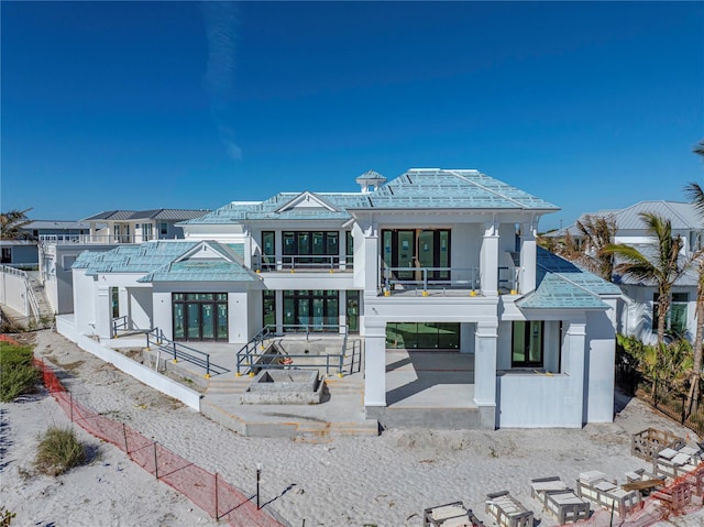 back of property featuring a balcony and a patio