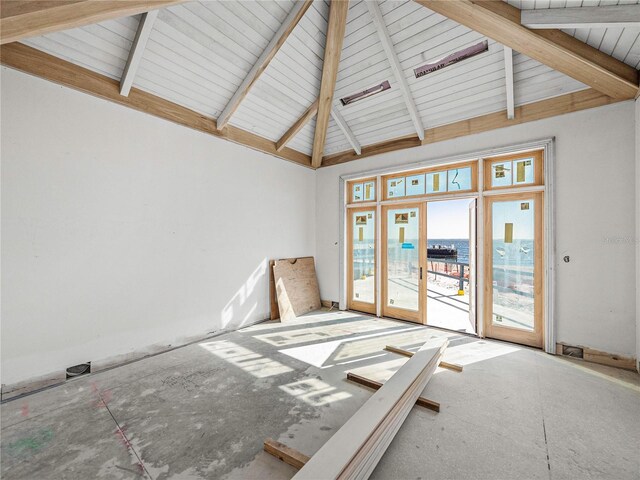 unfurnished room featuring beam ceiling, high vaulted ceiling, and french doors