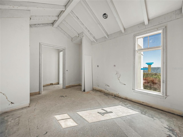 spare room featuring vaulted ceiling with beams and plenty of natural light