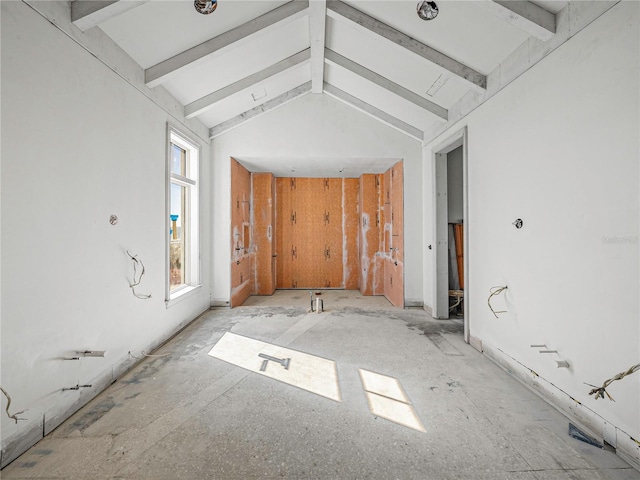 spare room with vaulted ceiling with beams and a healthy amount of sunlight