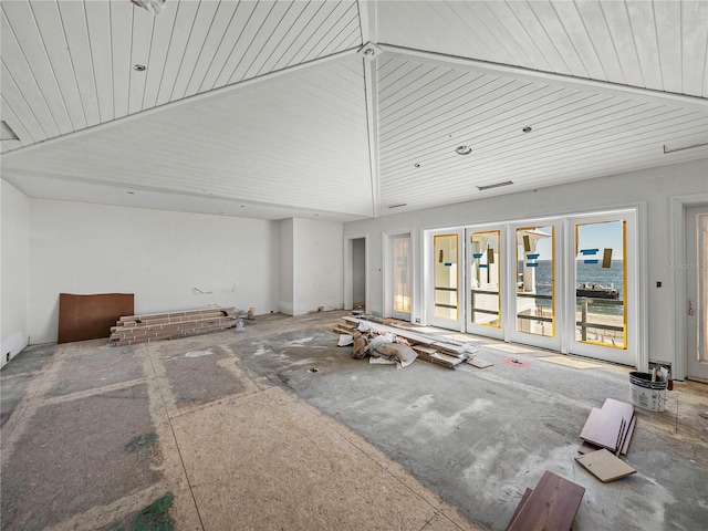 living room with a water view, french doors, and high vaulted ceiling