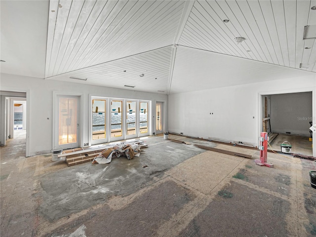 unfurnished living room with high vaulted ceiling