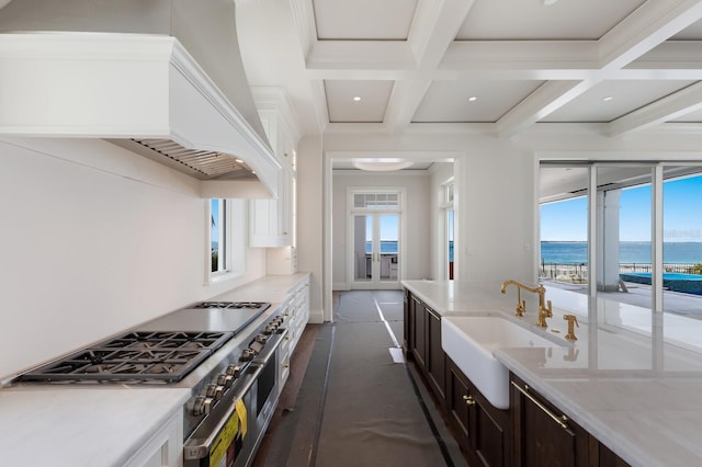 894 Hill Tide Ln, Boca Grande, FL 33921 - kitchen with a sink, range with two ovens, coffered ceiling, a water view, and custom exhaust hood