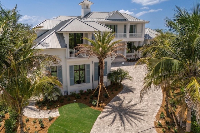 894 Hill Tide Ln, Boca Grande, FL 33921 - raised beach house with a balcony, a standing seam roof, metal roof, stucco siding, and driveway