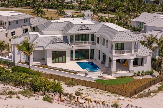 894 Hill Tide Ln, Boca Grande, FL 33921 - rear view of house featuring a balcony, a fenced backyard, a standing seam roof, a patio area, and stucco siding