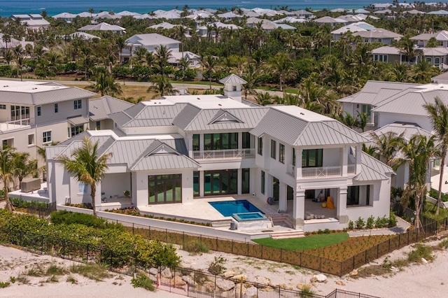 894 Hill Tide Ln, Boca Grande, FL 33921 - rear view of property featuring a fenced backyard, a balcony, a standing seam roof, a patio area, and stucco siding