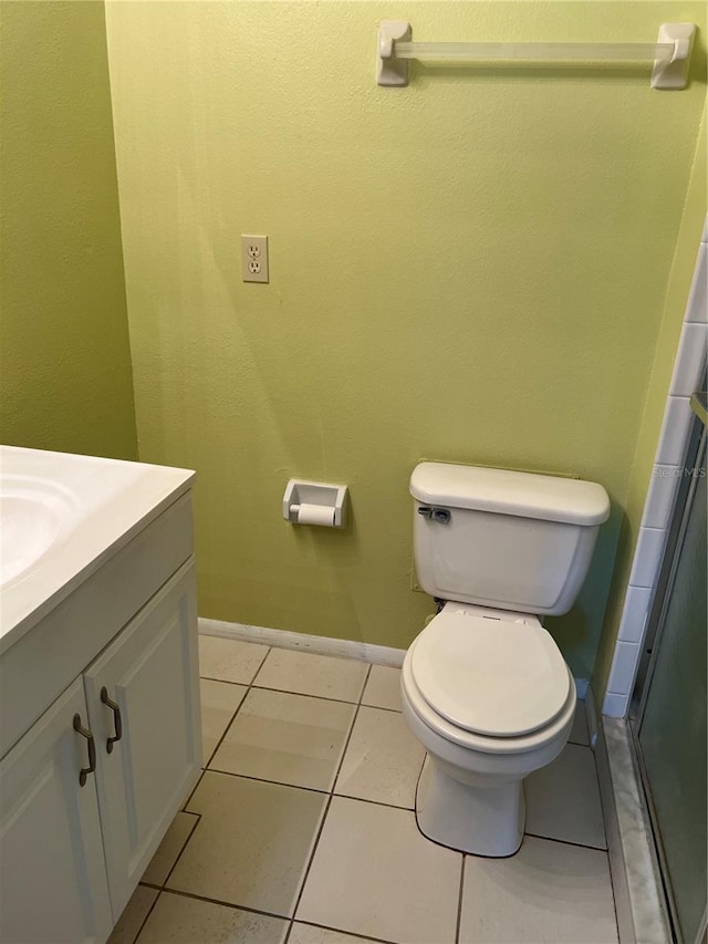 bathroom featuring toilet, vanity, and tile flooring