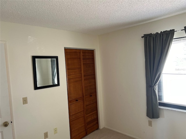 empty room with a textured ceiling and carpet flooring