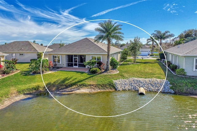 back of house with stucco siding, a lawn, and a water view