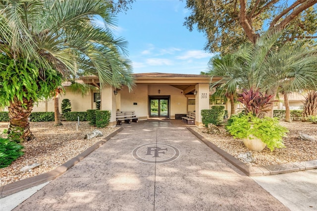 rear view of property featuring french doors and stucco siding