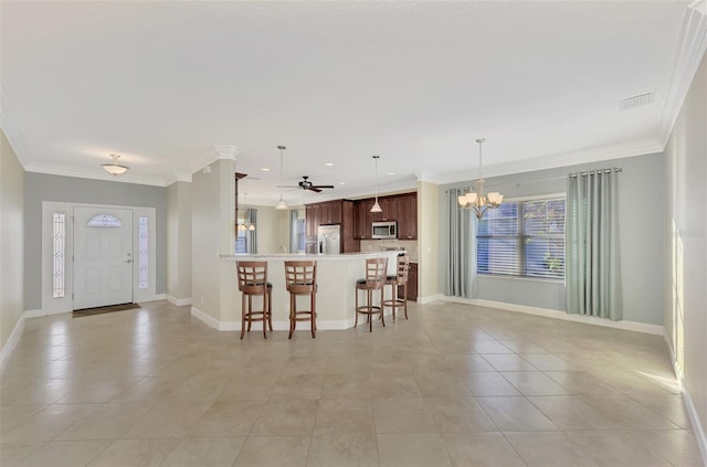 kitchen featuring visible vents, stainless steel appliances, light countertops, a kitchen bar, and crown molding