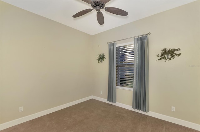 carpeted spare room featuring baseboards and ceiling fan