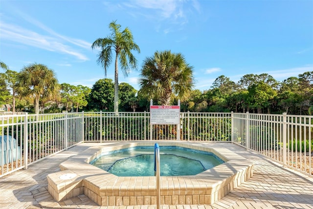 view of swimming pool with a community hot tub and fence