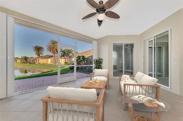 sunroom featuring a water view and ceiling fan