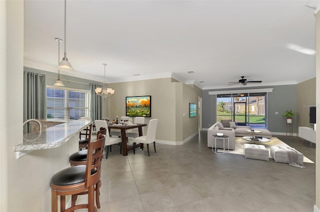 dining room featuring light tile patterned floors, ceiling fan with notable chandelier, crown molding, and baseboards