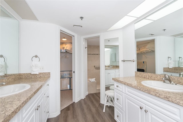 bathroom featuring hardwood / wood-style flooring, dual sinks, and oversized vanity