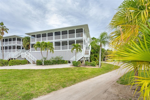 view of side of property featuring a yard and a sunroom