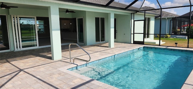 view of swimming pool featuring glass enclosure, ceiling fan, and a patio area