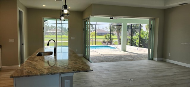 doorway to outside featuring a wealth of natural light, sink, and light wood-type flooring