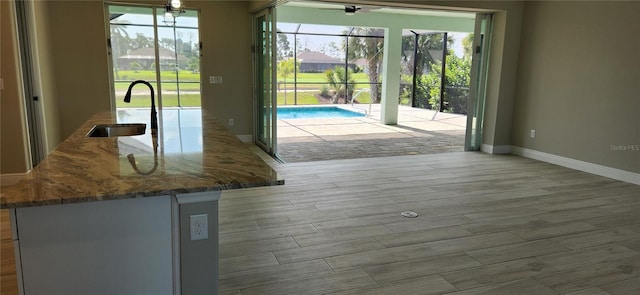 kitchen with stone countertops, a healthy amount of sunlight, and sink