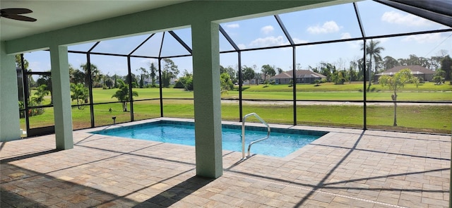 view of pool featuring a patio, ceiling fan, a lanai, and a lawn