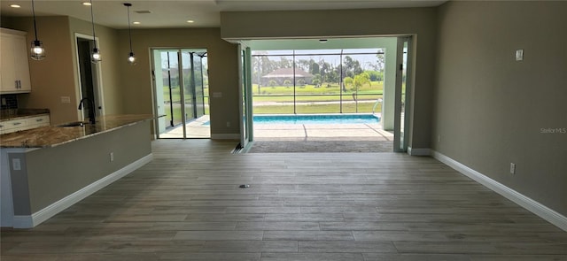 doorway to outside with sink, dark wood-type flooring, and plenty of natural light